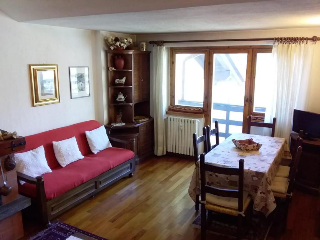 a living room with a red couch and a table at Monte Cervino apartment AS14 in Breuil-Cervinia