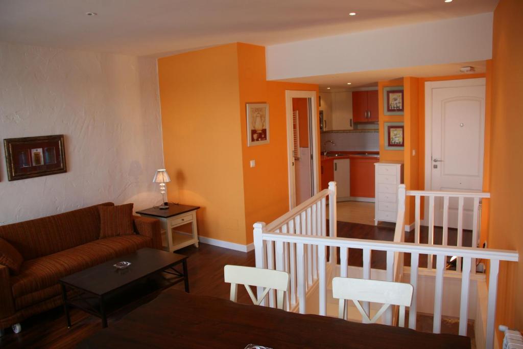a living room with a couch and a kitchen at Apartamentos Rincón del Puerto in San Vicente de la Barquera