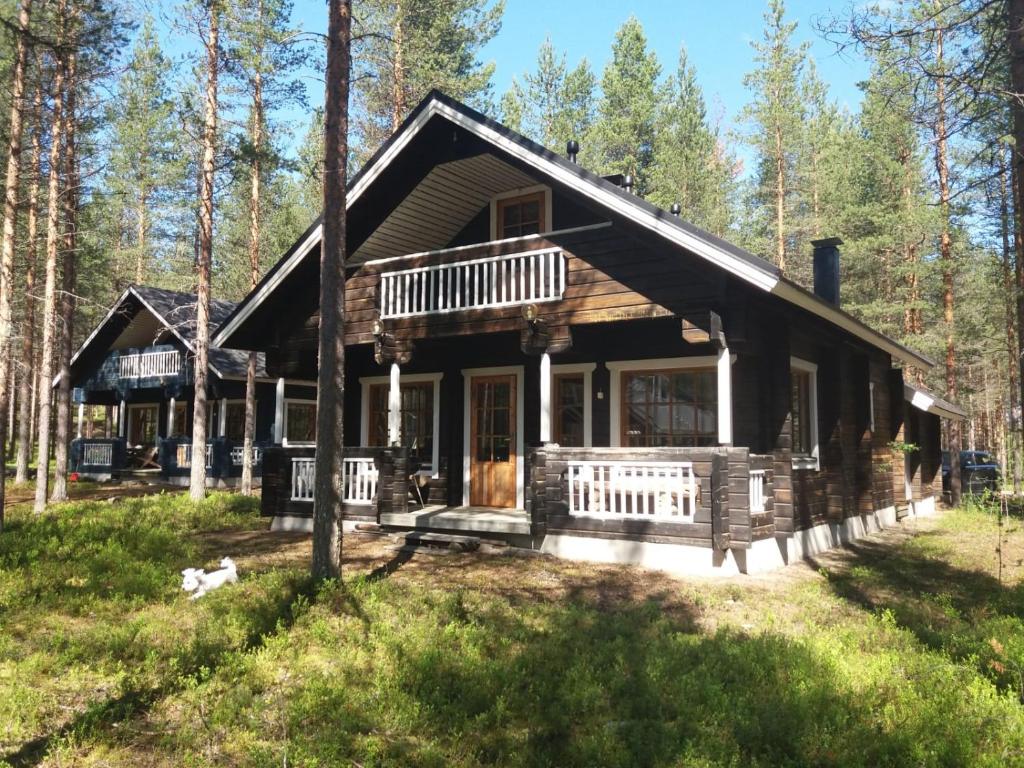 a log cabin in the woods with trees at PyhäBerry in Pelkosenniemi