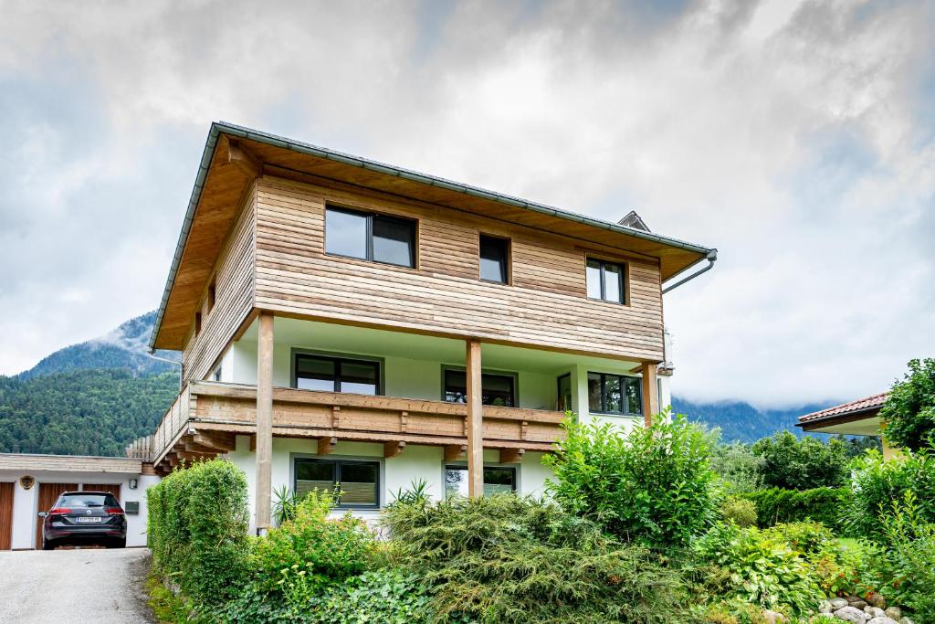 una casa in legno con montagne sullo sfondo di Ferienwohnung Ellmerer a Schwoich