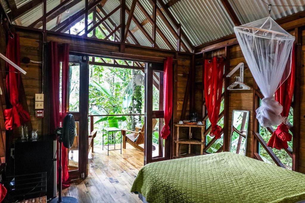 1 dormitorio con 1 cama en una habitación con ventana en Surf Break at Paunch, en Bocas Town