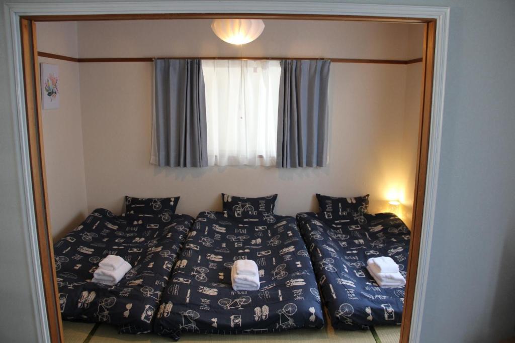 ein Spiegelbild eines Schlafzimmers mit 2 Betten und einem Fenster in der Unterkunft It's Kasuga Town B Building / Vacation STAY 60078 in Kasugabaru