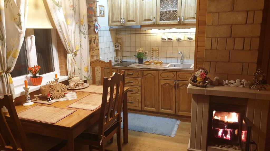 eine Küche mit einem Holztisch und einem Kamin in der Unterkunft Jurmala's Center Eco House in Jūrmala