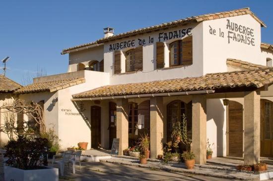 - un grand bâtiment blanc avec un panneau dans l'établissement Auberge de la Fadaise, à Saintes-Maries-de-la-Mer