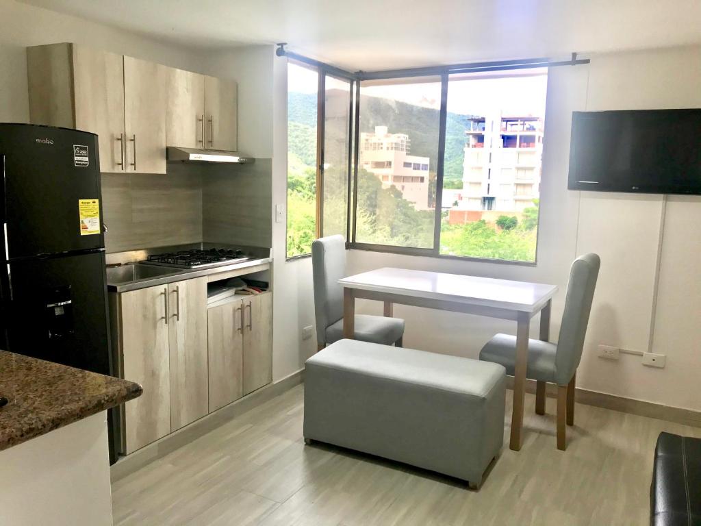 una pequeña cocina con mesa y ventana en Caribbean Venture Apto 303 - Rodadero, Santa Marta, en Santa Marta