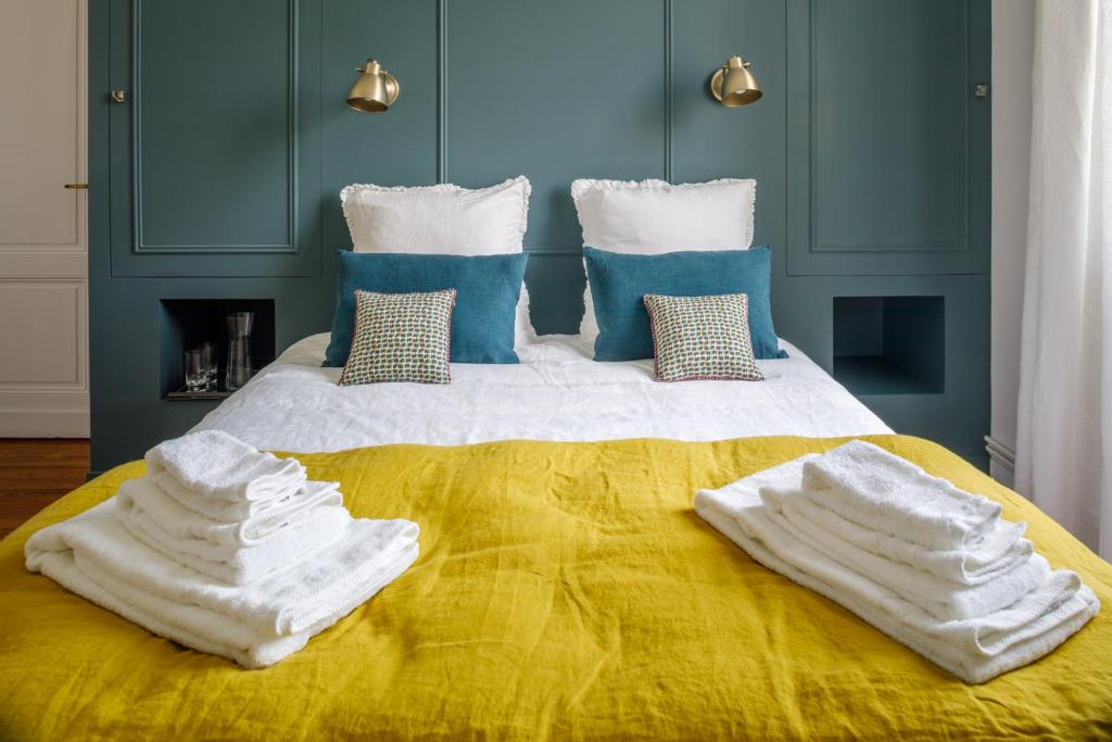 a bed with white towels on top of it at Le Clos Labottière - B&B in Bordeaux