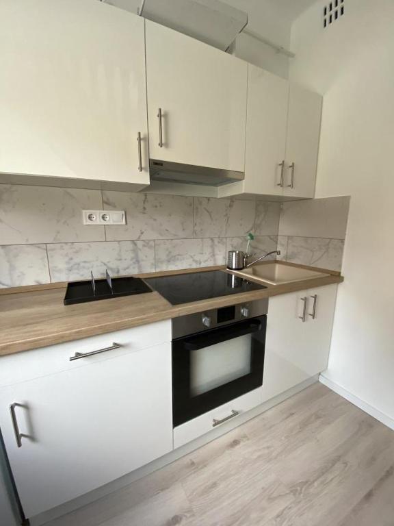 iHome Apartman 8.0 في بيتْش: مطبخ مع دواليب بيضاء ومغسلة