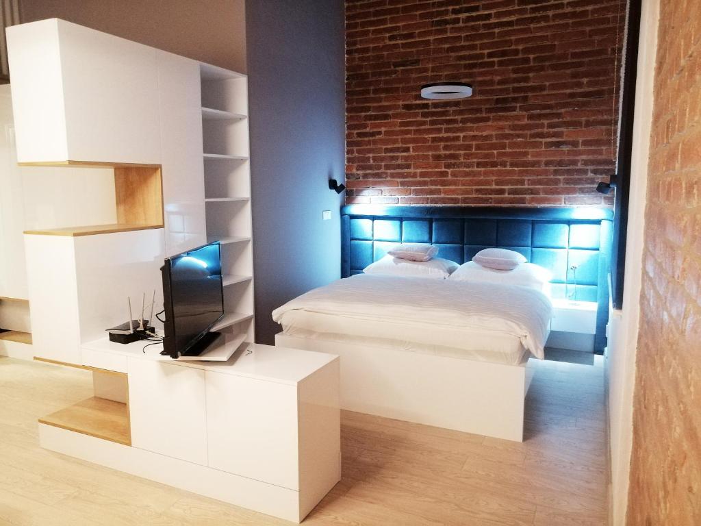 a bedroom with a bed and a brick wall at Entrez Apartments 4 - City centre in Košice