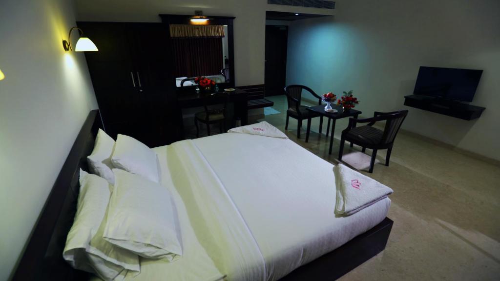Postel nebo postele na pokoji v ubytování Lakshmi Hotel