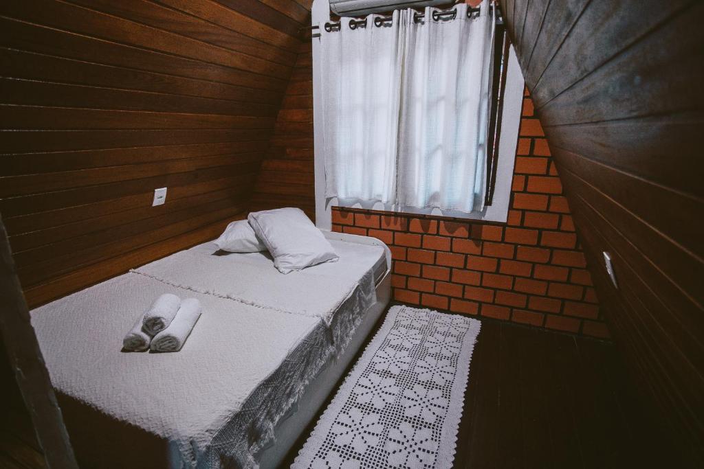 a small room with a bed and a window at Chale da Mole in Florianópolis