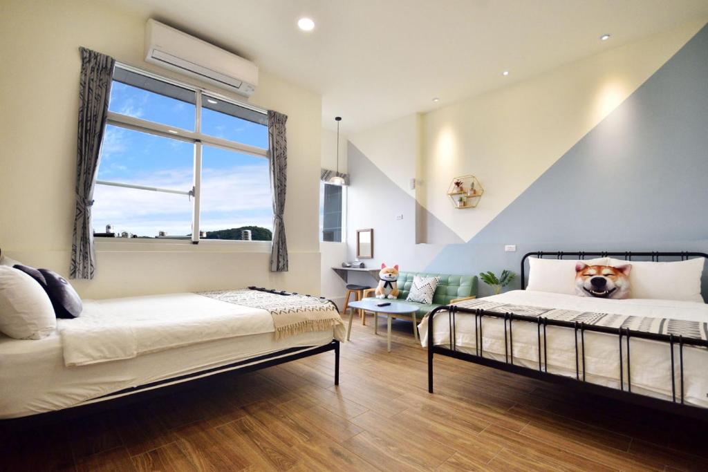 a bedroom with two beds and a window at Piau Po 21 Inn in Taitung City