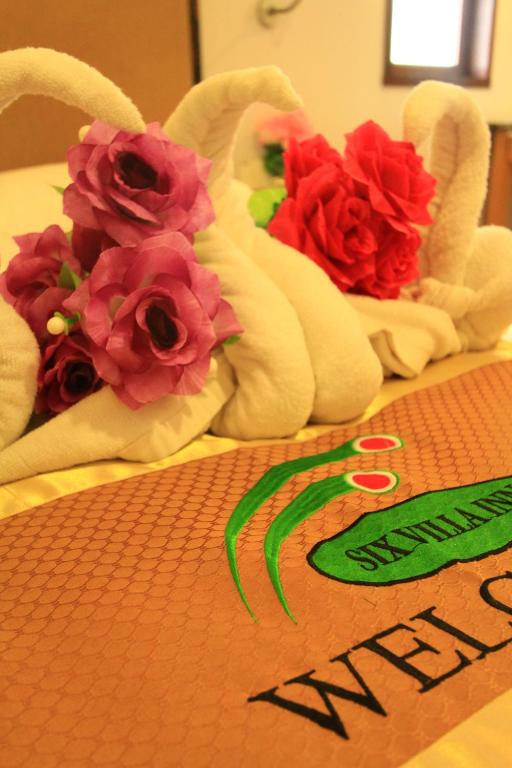 龍運的住宿－SIX VILLA INN，一组毛巾,桌子上放着鲜花