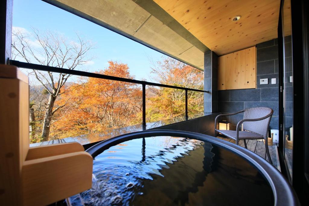 una piscina en una casa con vistas a los árboles en Centurion Hakone Bettei, en Hakone