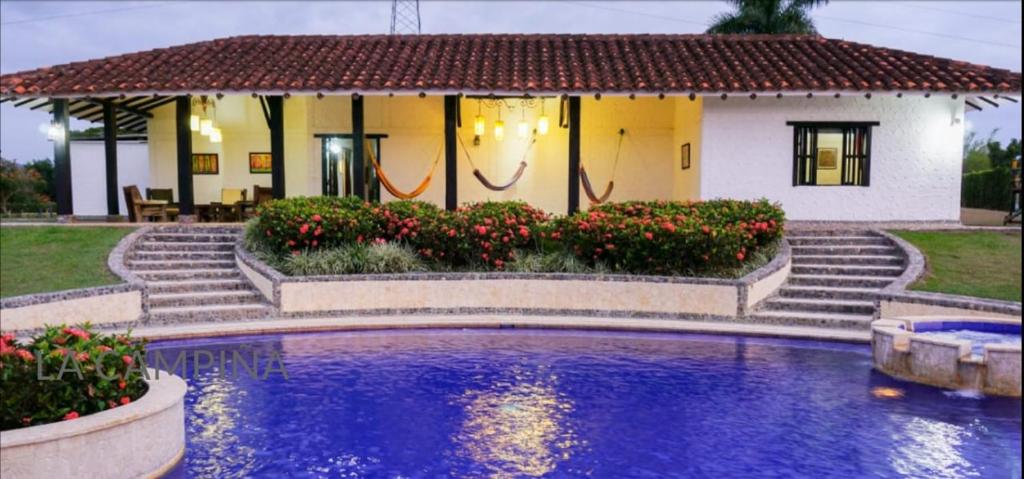 una casa con piscina frente a una casa en CASA CAMPESTRE LA CAMPIÑA LA VICTORIA Valle del Cauca ESPACIO COMPLETO-desayuno a pareja, en Matazarza