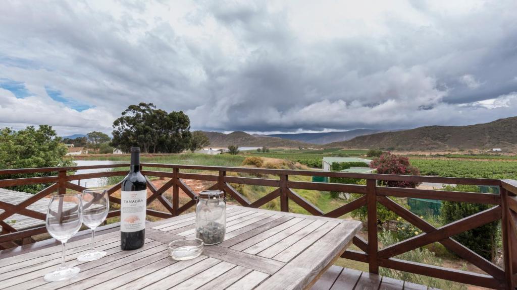 una botella de vino en una mesa de madera con copas de vino en Tanagra Wine & Guestfarm, en McGregor