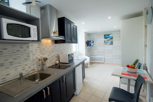 a kitchen with a sink and a microwave at Studio Mer , résidence Excelsior in Bagnères-de-Bigorre