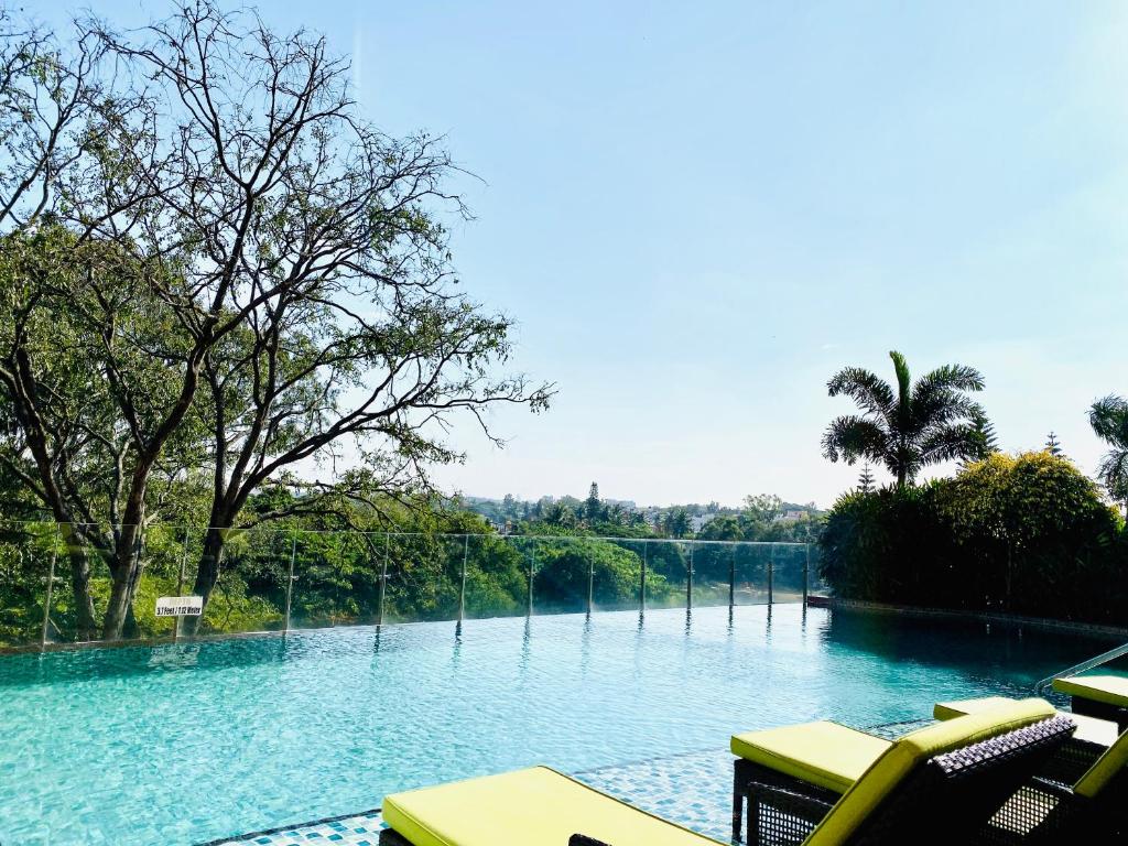 uma grande piscina de água com cadeiras e árvores em Welcomhotel by ITC Hotels, Richmond Road, Bengaluru em Bangalore