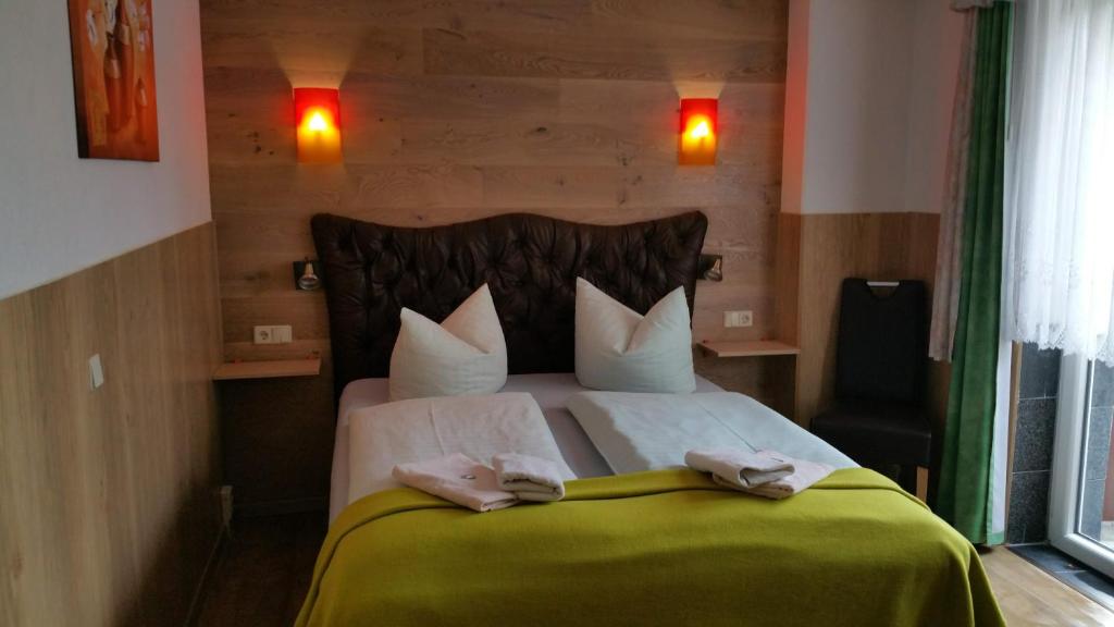 SohlandにあるLandhotel Waldschlößchen mit Gaststubeのベッドとタオル2枚のある寝室