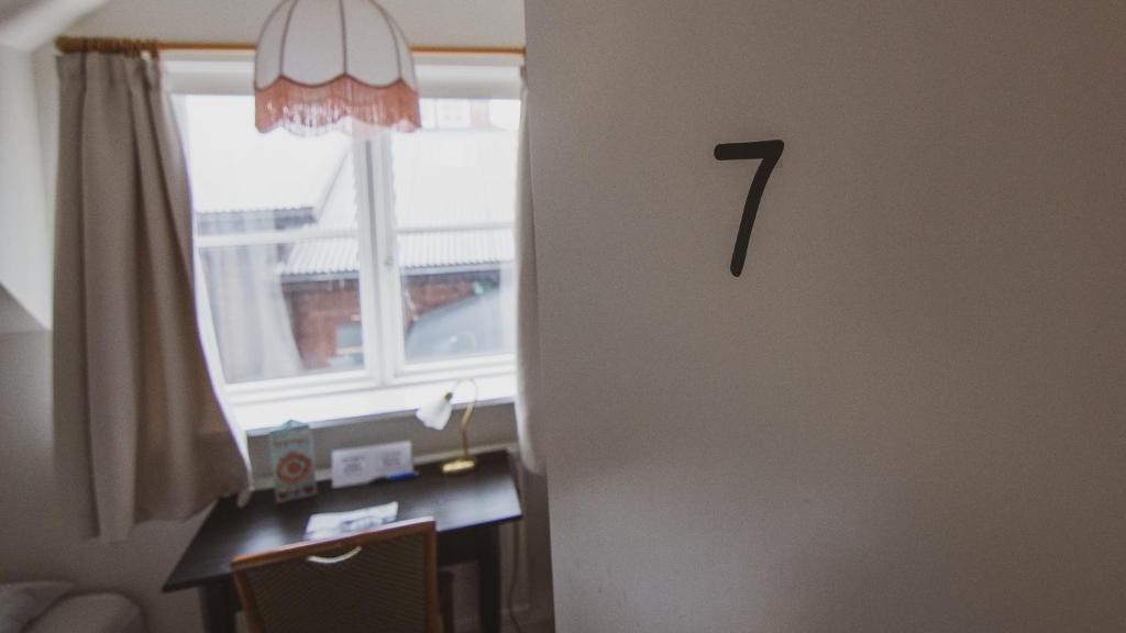 a door with a number seven written on it next to a window at Hotel Framtid in Djúpivogur