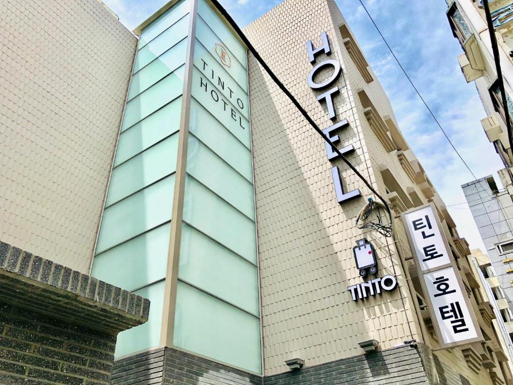 
a tall building with a sign on the side of it at Tinto Hotel in Busan
