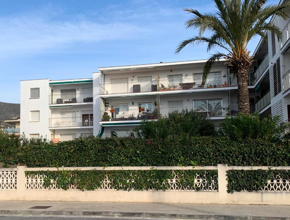 een appartementencomplex met een palmboom ervoor bij Solimar in Castelldefels