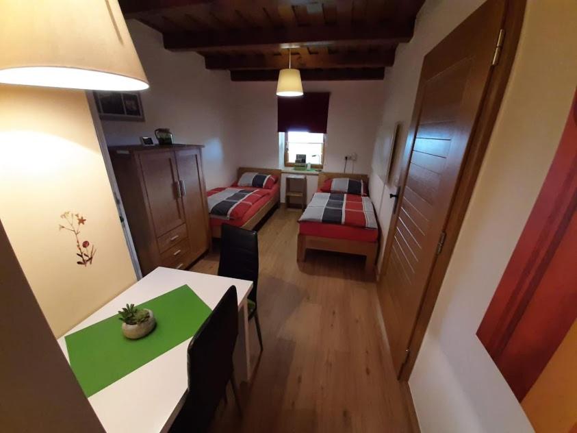 Kleines Zimmer mit 2 Betten und einem Tisch in der Unterkunft Kellerstöckl Kamper in Eisenberg an der Pinka