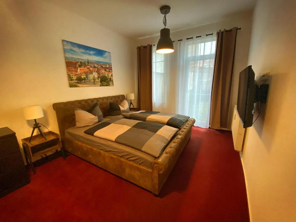 um quarto com uma cama, um sofá e uma televisão em Suite an der Lutherkirche em Erfurt