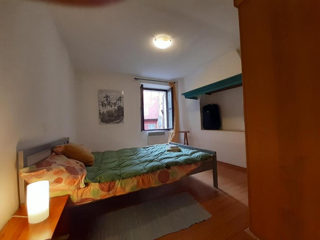 mała sypialnia z łóżkiem i oknem w obiekcie Apartment Zdenac Lux w Rovinj