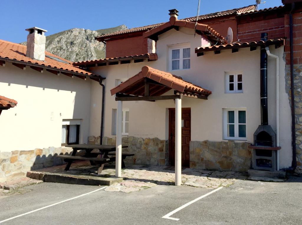 a house with a picnic table in a parking lot at La Casina de La Casona in Sobrepiedra