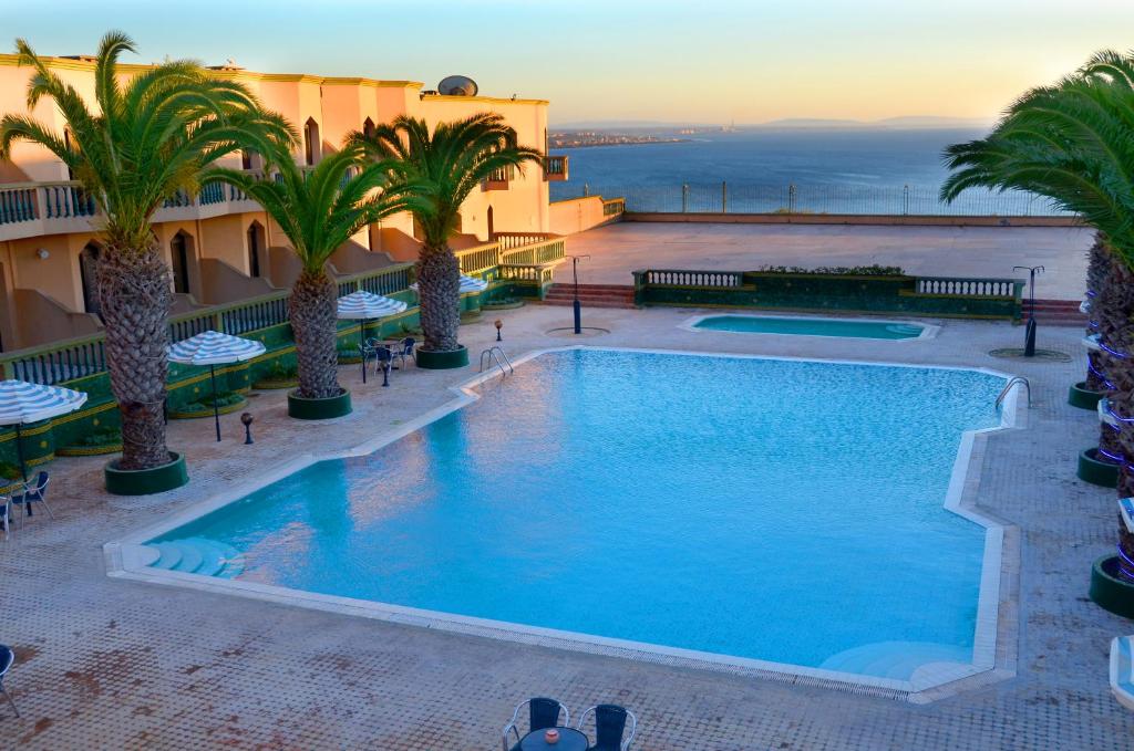 ein Bild eines Pools in einem Hotel mit Palmen in der Unterkunft Hôtel Atlantique Panorama in Safi