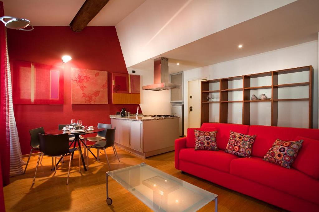 uma sala de estar com um sofá vermelho e uma mesa em FILARMONICO SUITES em Verona