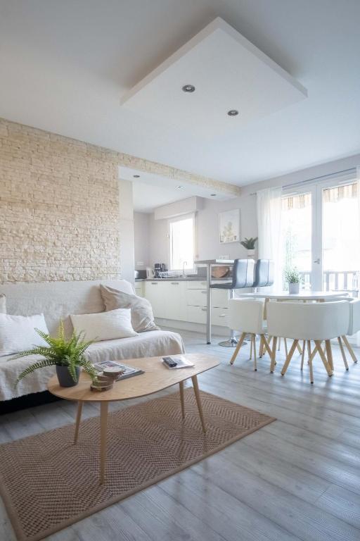 un salon avec un canapé et une table dans l'établissement Appartement Cocooning à Cabourg - Les locations de Proust, à Cabourg