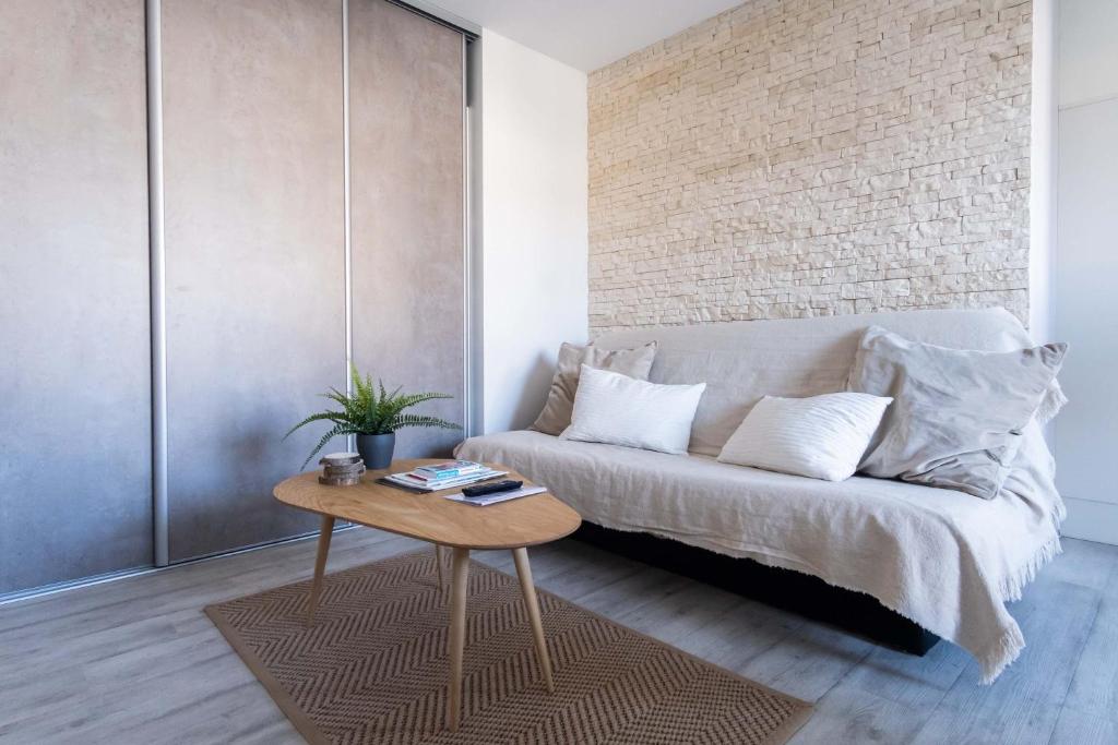 a living room with a bed and a table at Appartement Cocooning à Cabourg - Les locations de Proust in Cabourg