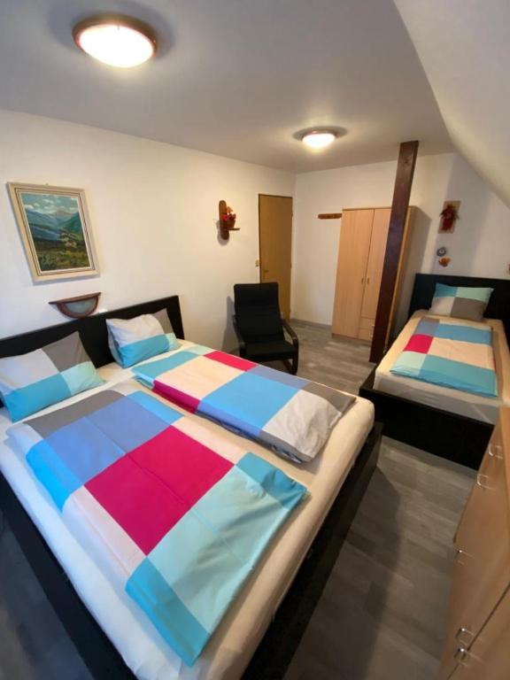 sypialnia z dwoma łóżkami i krzesłem w obiekcie Ubytování MAPE, Rokytnice nad Jizerou, Horní 679, 512 44 w Rokitnicach nad Izerą
