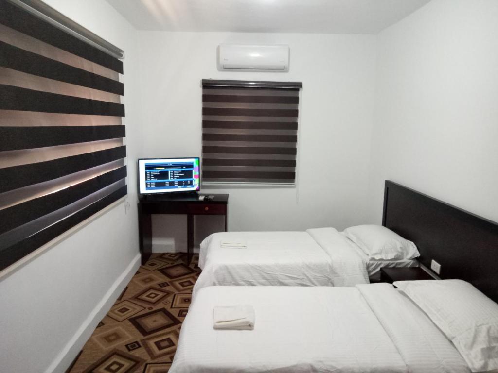 Kleines Zimmer mit 2 Betten und einem TV in der Unterkunft Happy Night Hostel in Wadi Musa