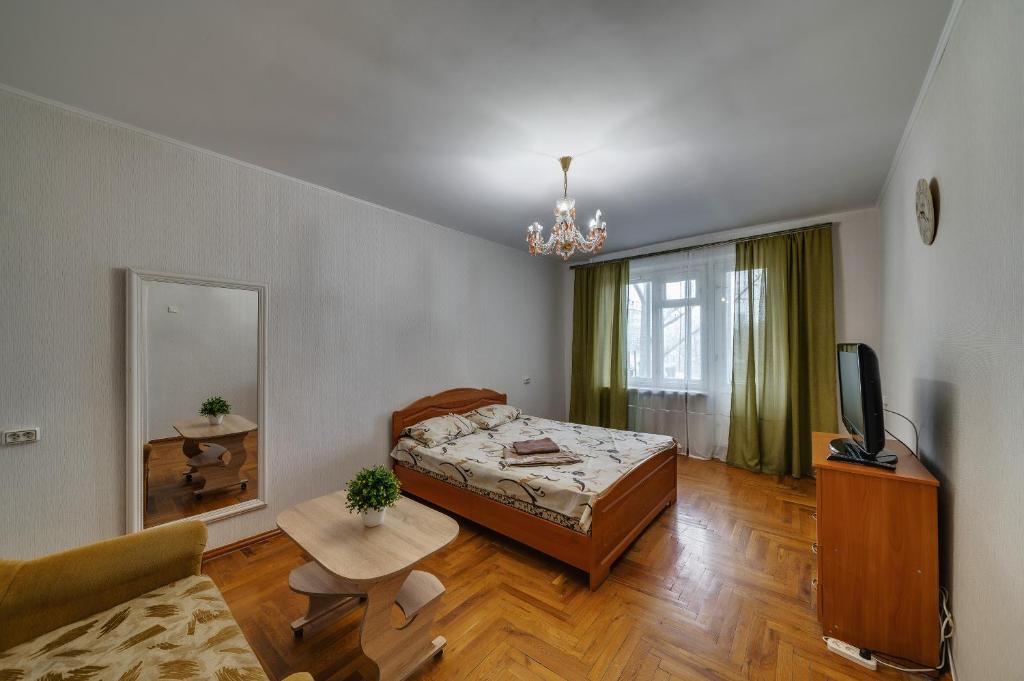 a bedroom with a bed and a tv and a couch at Alexandrovskaya street in Zaporozhye