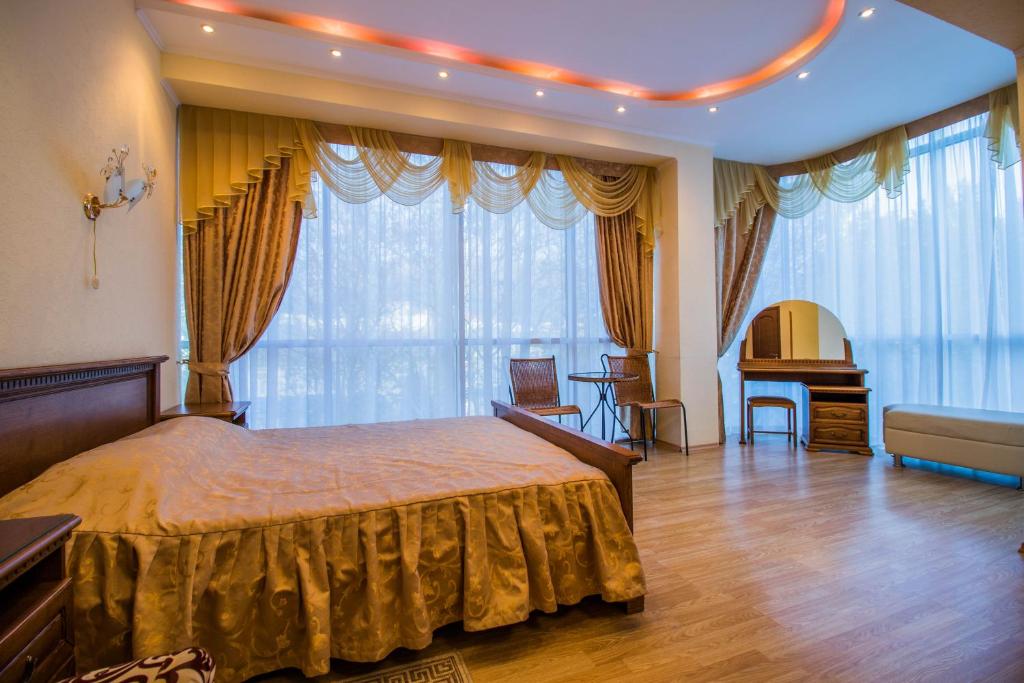 a bedroom with a bed and a desk in a room at Hotel Moskva in Gelendzhik