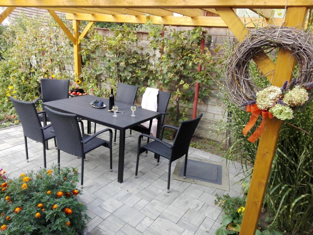 d'une terrasse avec une table, des chaises et une clôture. dans l'établissement Apartmán U Zastávky, à Ratíškovice