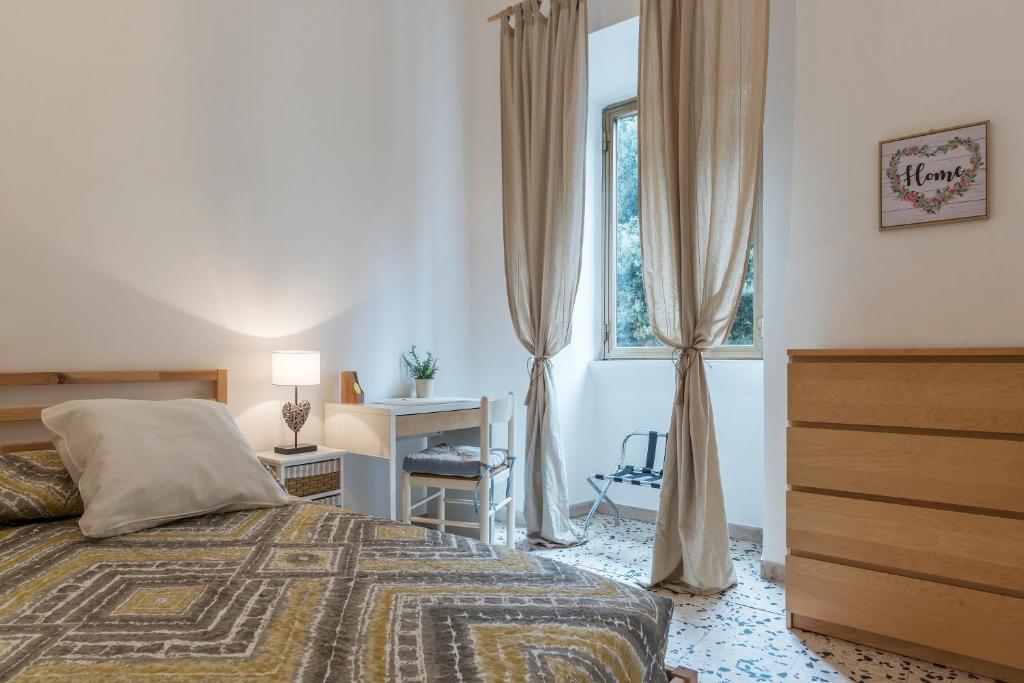 sypialnia z łóżkiem, biurkiem i oknem w obiekcie Ad un passo da Villa Borghese Apartment w Rzymie