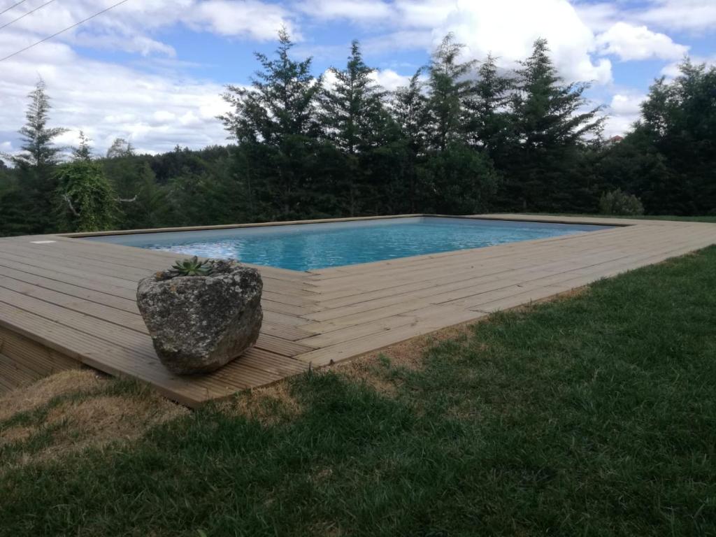 einen Pool auf einer Holzterrasse im Gras in der Unterkunft Quinta Rural - Nossa Sra do Carmo. Teixoso in Teixoso