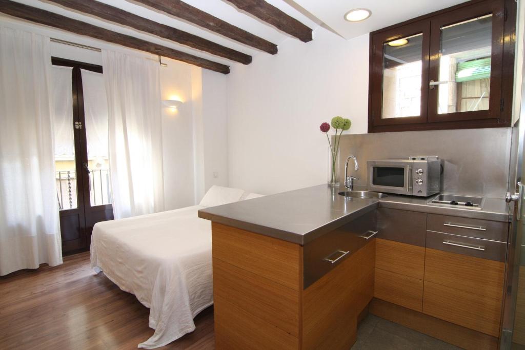 バルセロナにあるBCN2ステイ アパートメンツのキッチン(電子レンジ付)、ベッド1台が備わります。