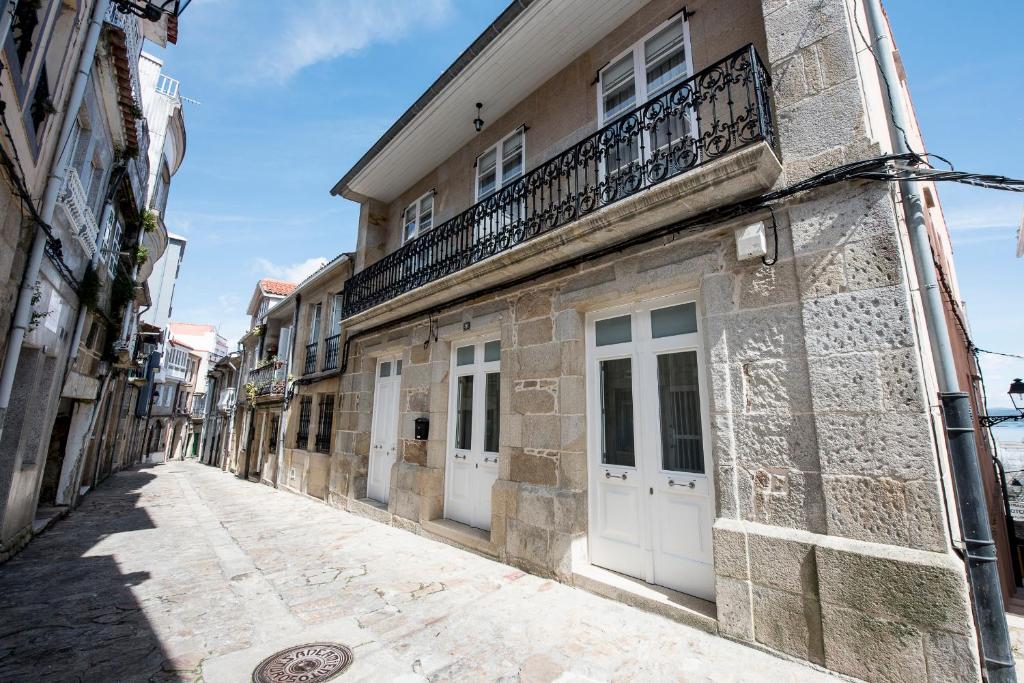 un callejón en un edificio antiguo con puertas blancas en Pension Casa da Nena, en Muros