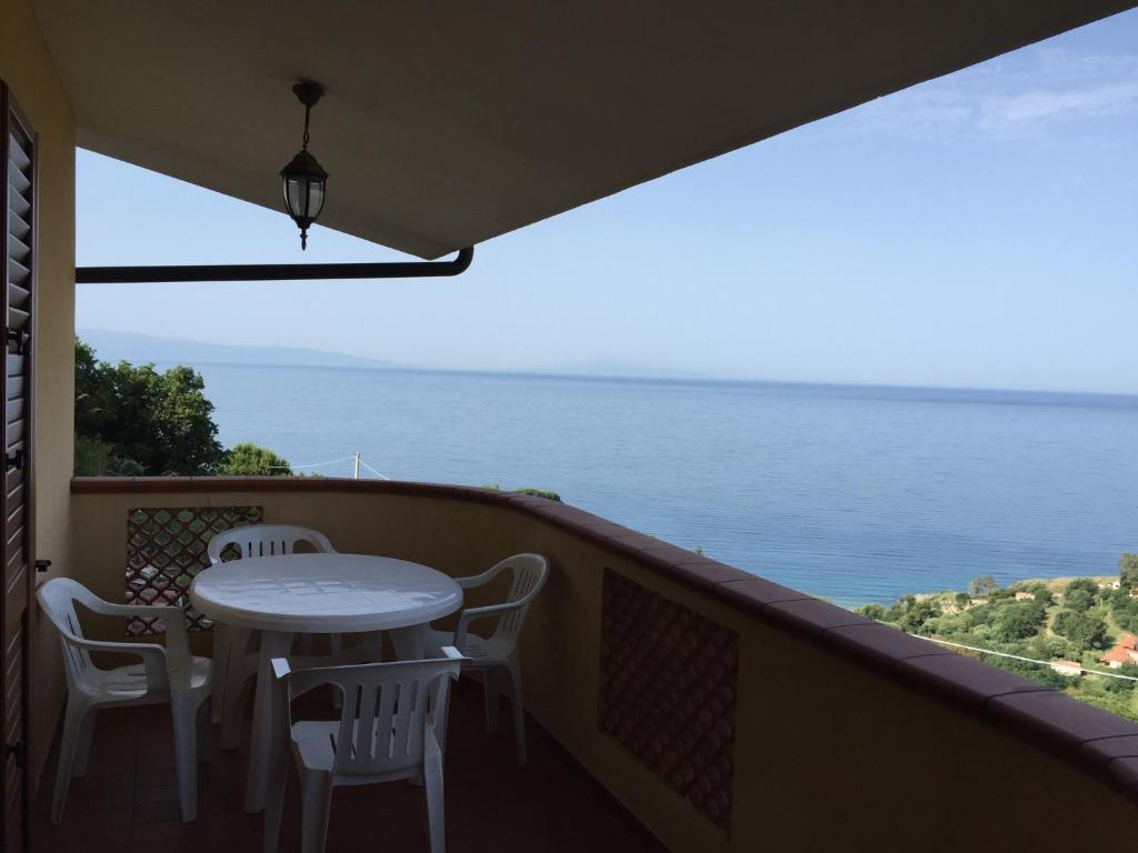 a balcony with a table and chairs and the ocean at Villa Bella Vista in Capo Vaticano