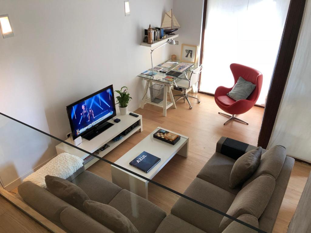 a living room with a couch and a tv at Loft Las Arenas Getxo junto puente colgante Bilbao in Getxo