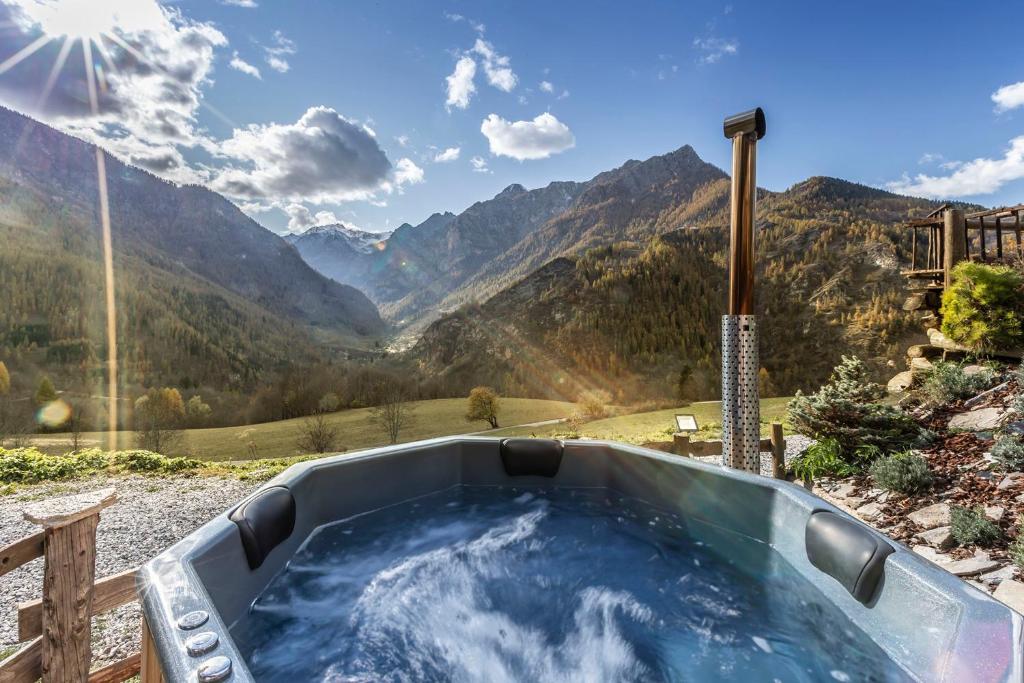 a jacuzzi tub with a view of mountains at Brieis Relais Alpino in Marmora