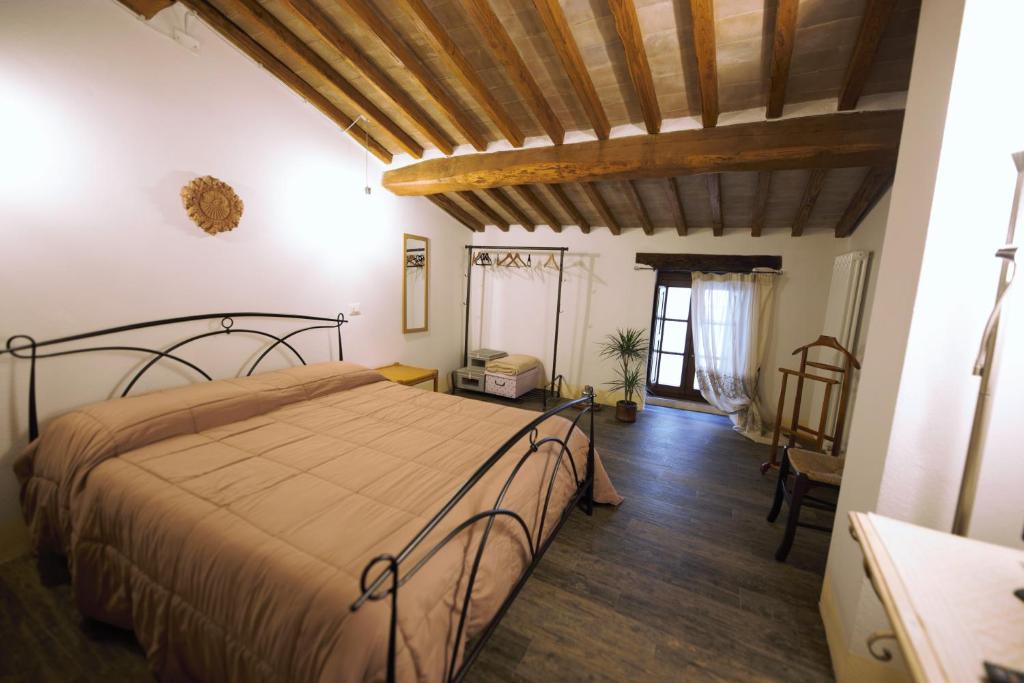 um quarto com uma cama e piso em madeira em Camere La Carbonaia em Pienza