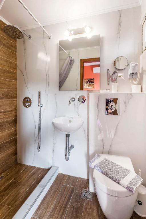 a bathroom with a toilet and a sink at Hotel Almira in Agia Triada