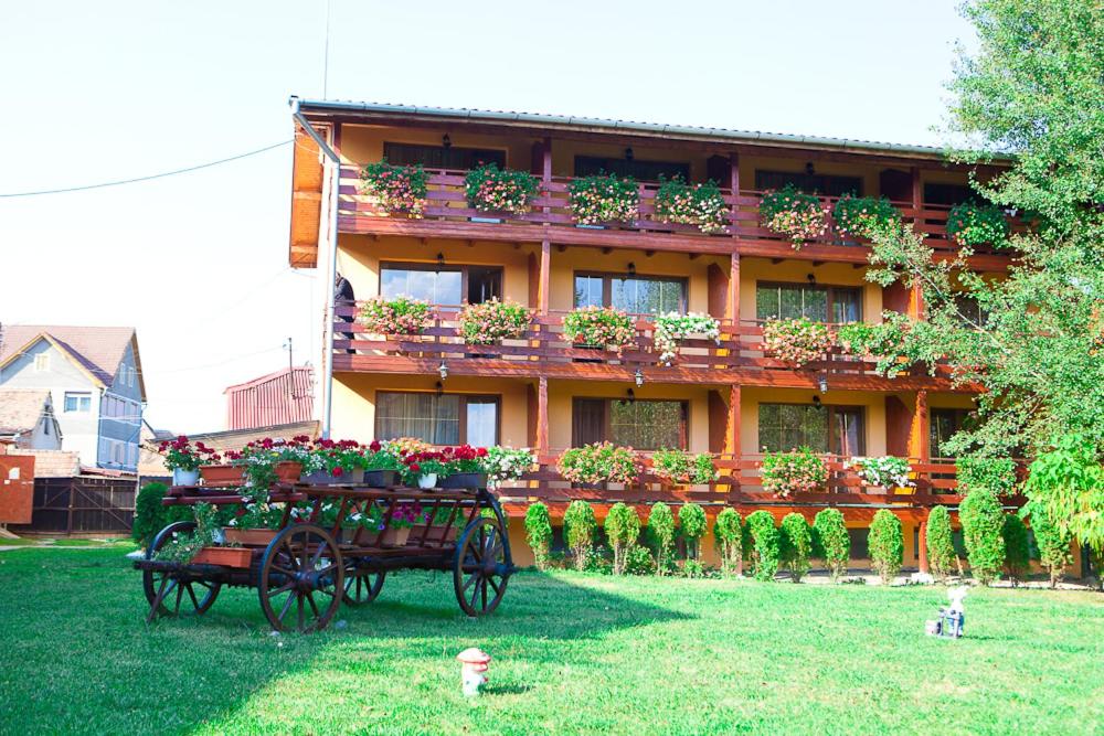 a horse drawn carriage in front of a building with flower boxes at Casa Bazna in Bazna