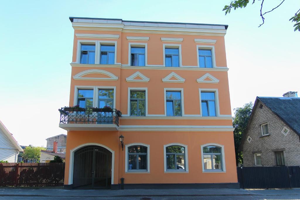 un gran edificio naranja con balcón. en Marbella Rezidence, en Ventspils