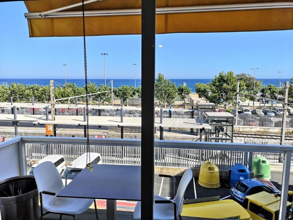 Luxury Apartment Accommodation, next to beach & train station Calella في كليلة: شرفة مع طاولة وكراسي والمحيط